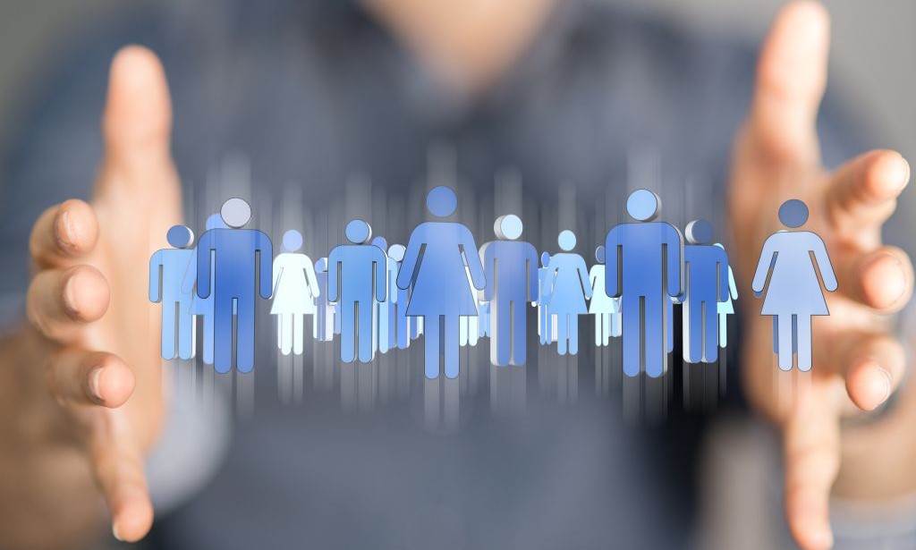 Illustratives Bild: Eine Person hält die Hände nebeneinander und dazwischen sieht man blaue Personenicons.  