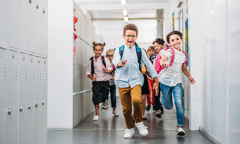 Eine Gruppe von kleinen Kindern läuft durch einen Flur.