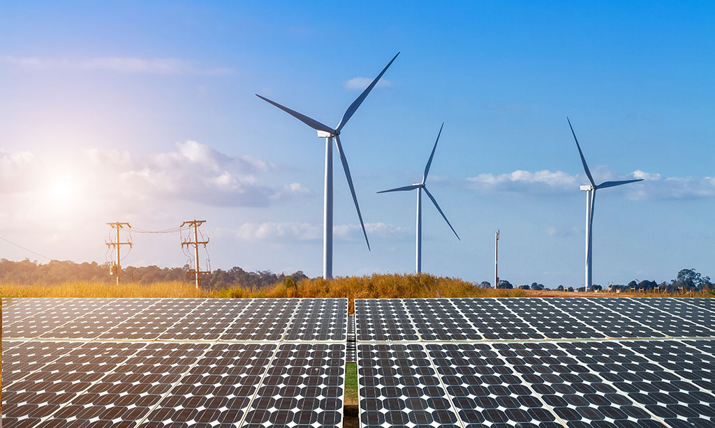 Windräder und Solar-Paneelen stehen auf einem Feld.