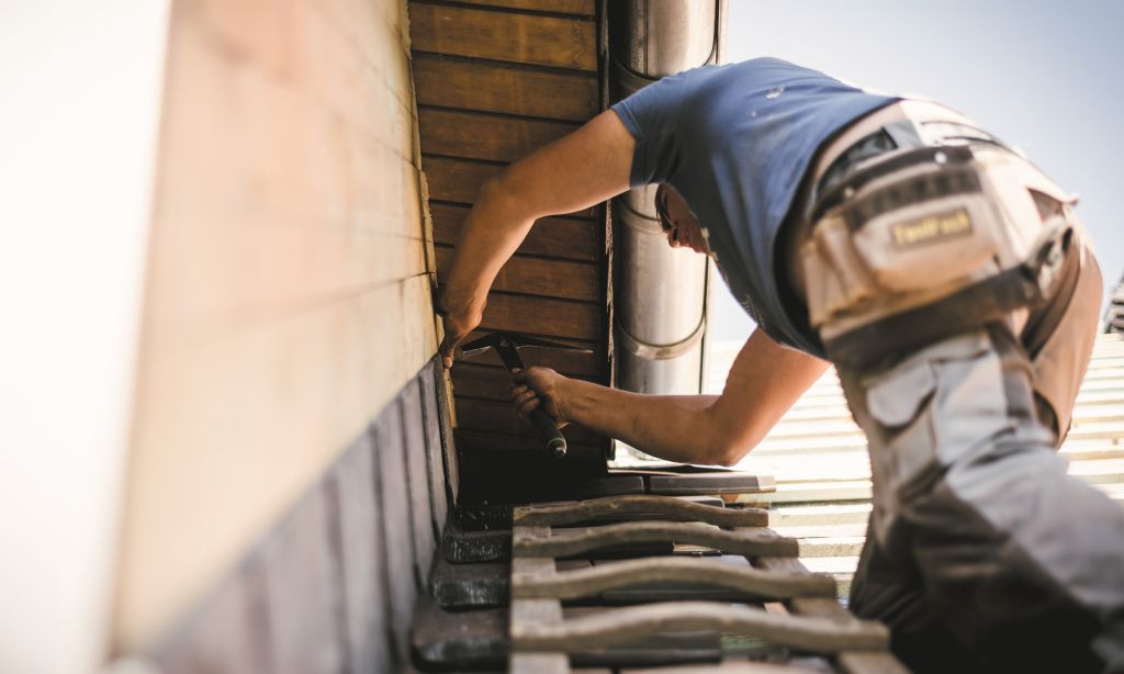 Ein Handwerker arbeitet auf einem Dach.