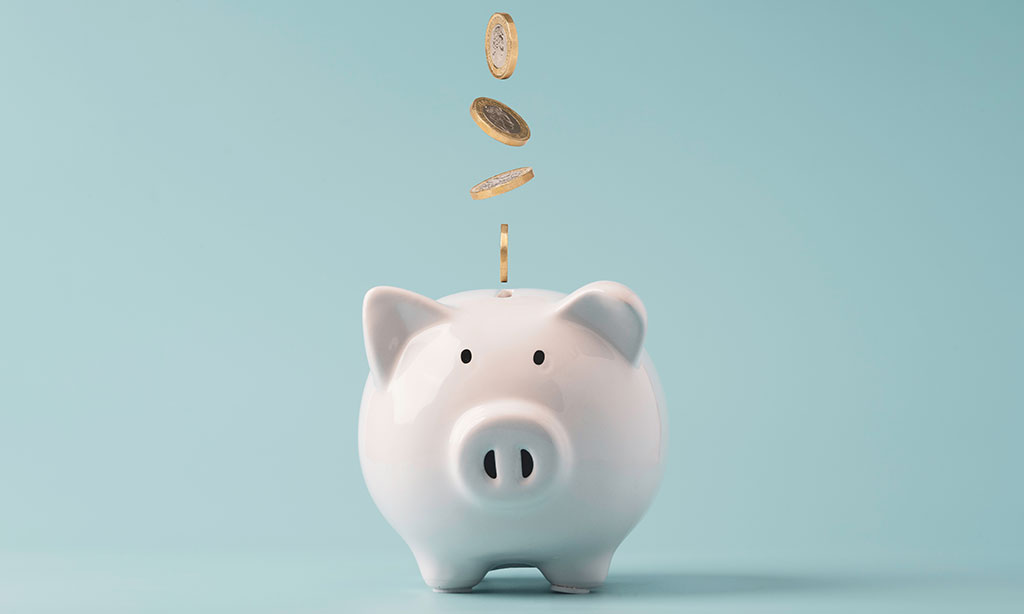 Euro-Münzen fallen in ein Sparschwein