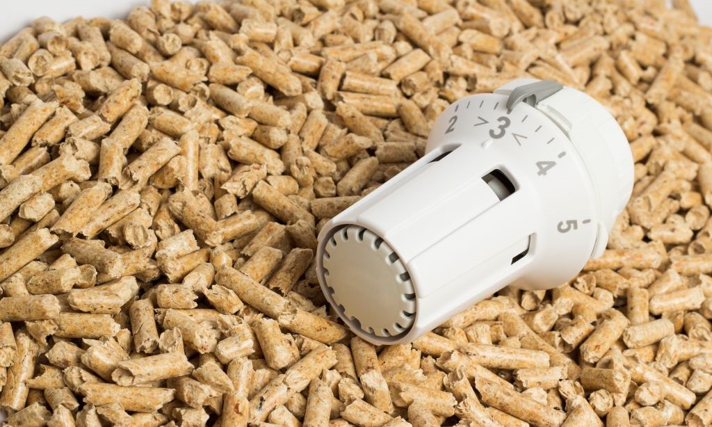 Ein Thermostat liegt auf einem Haufen Holzpellets