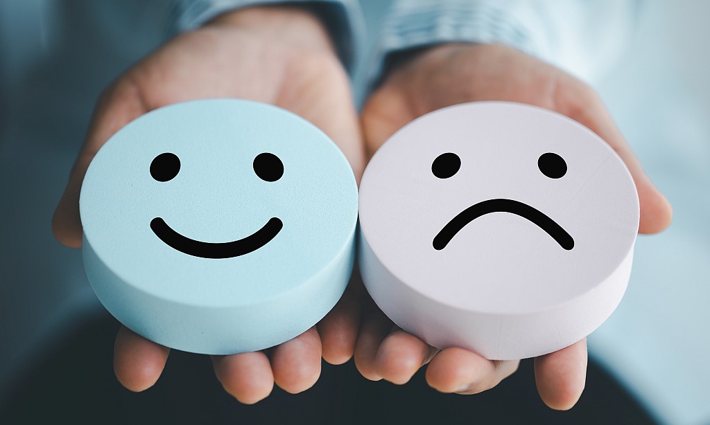 Eine Hand hält zwei Smileys nach oben.