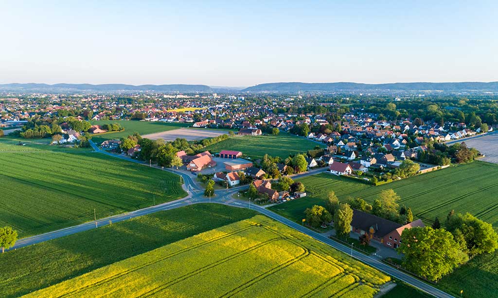 Luftaufnahme einer Wohnsiedlung umringt von Feldern