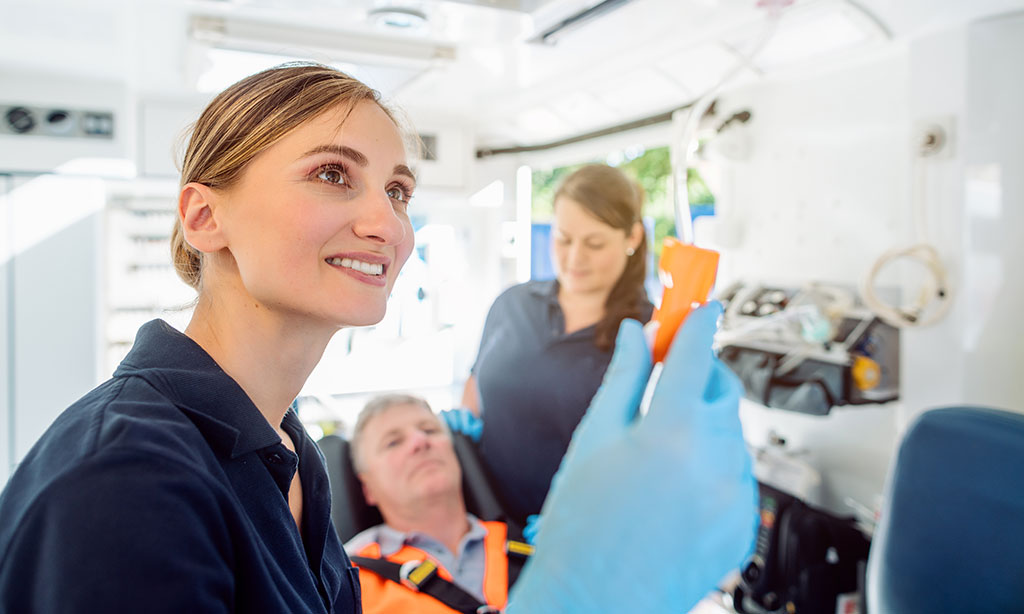 Sanitäter begleiten einen Patienten in einem Krankenwagen.