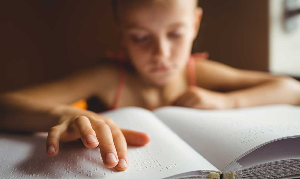 Ein blindes Mädchen liest Brailleschrift
