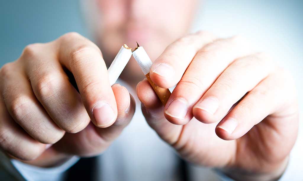 Ein Mann hält eine übergebrochene Zigarette in der Hand