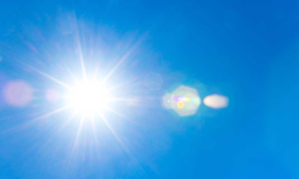 Die Sonne strahlt am Himmel.
