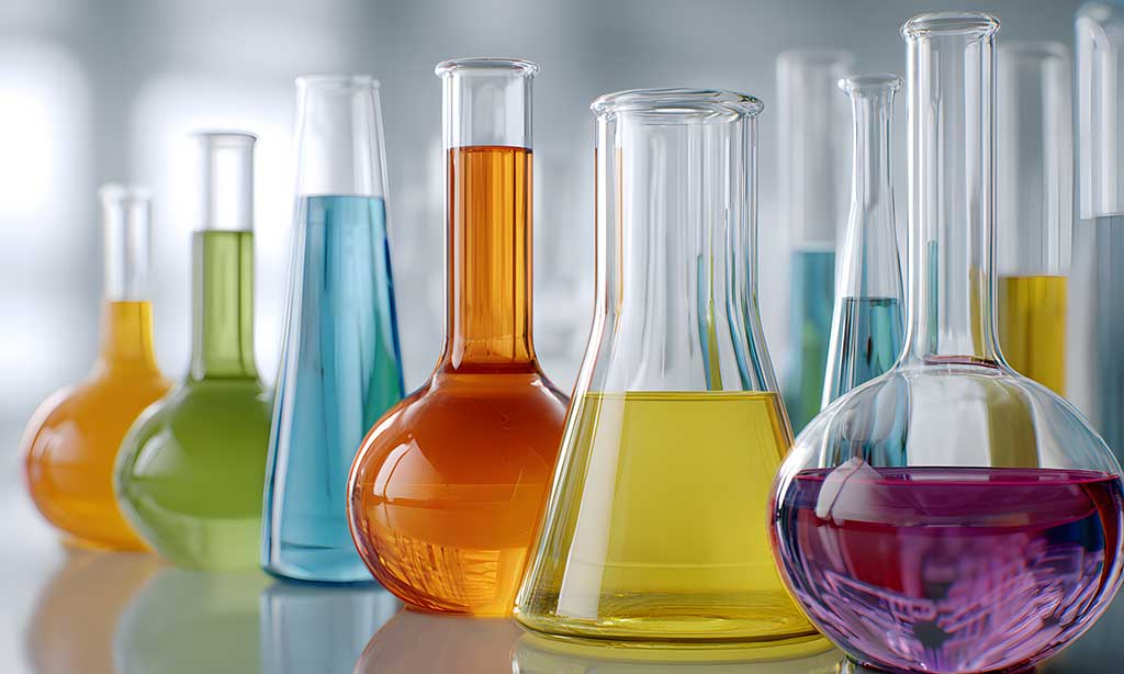 Verschiedene Laborgefäße mit farbigen Flüssigkeiten im modernen Chemielabor