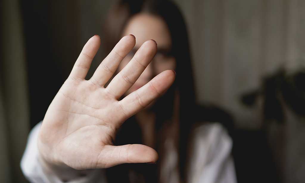 Eine Frau hält die Hand mit der Handfläche nach vorne vor sich ausgestreckt.