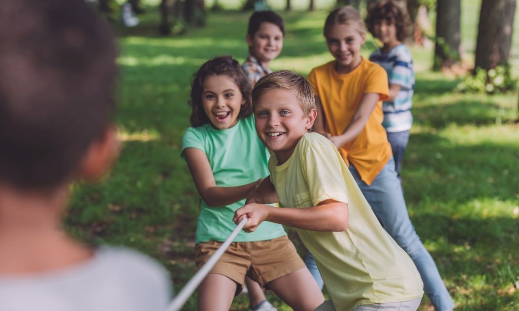 Kinder spielen Tauziehen. 