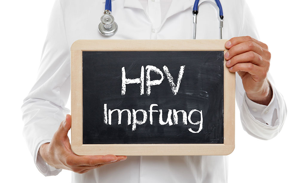 Ein Arzt hält eine Tafel auf der HPV steht.