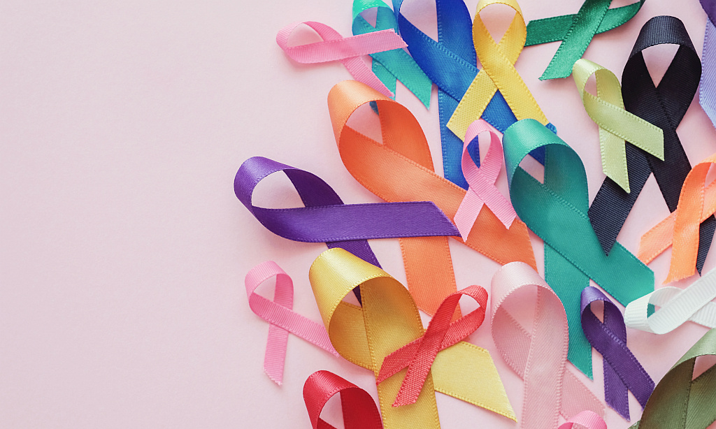 Schleifen, Symbol für den Weltkrebstag, vor rosa Hintergrund