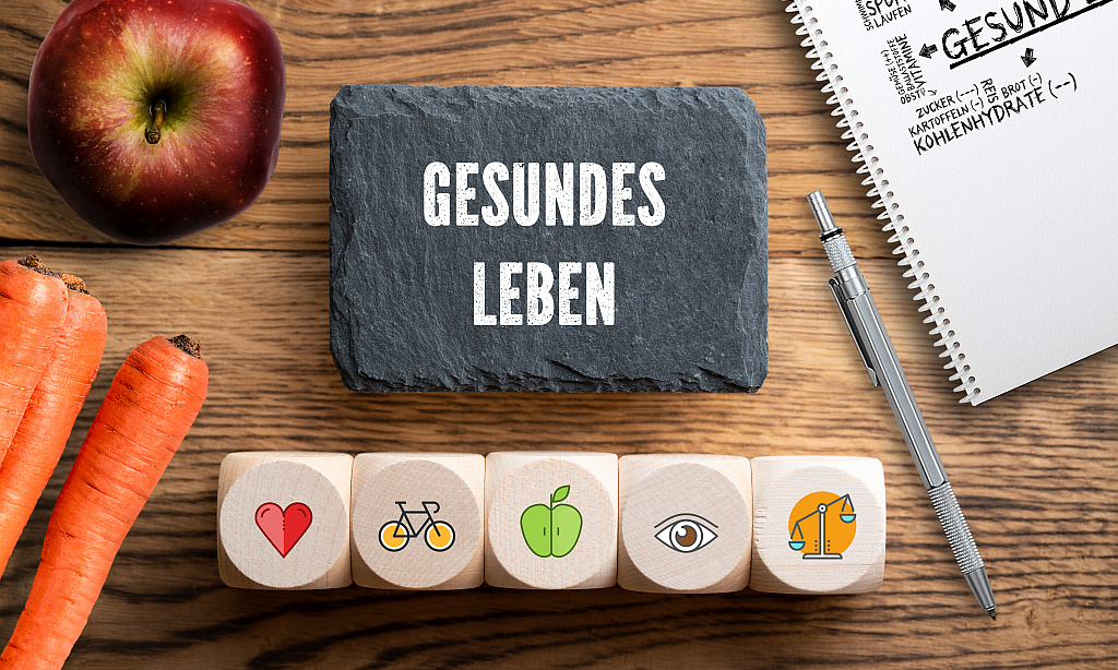 Würfel mit Symbolen und Schiefertafel mit der Aufschrift gesundes Leben