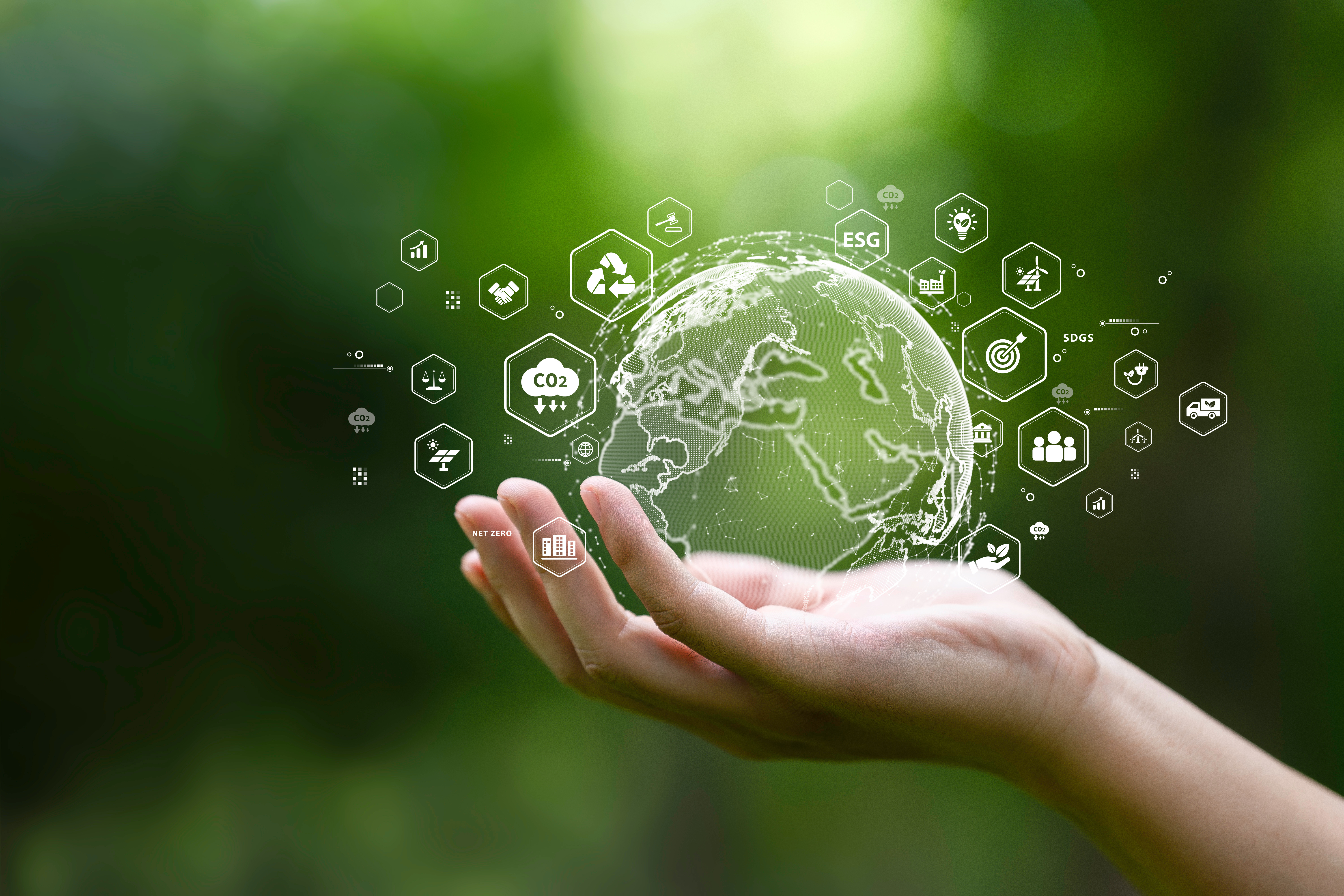 Eine Hand hält eine Miniatur-Erde und drum herum sind Symbole angeordnet, die für die verschiedenen Faktoren des Klimaschutzes stehen: Recycling, Verminderung des CO2-Ausstoßes, Verkehr, alternative Energien etc..