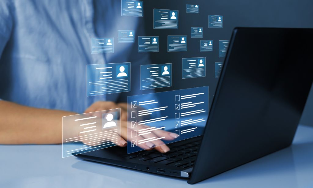 Beschäftigte gibt am Laptop Personendaten ein
