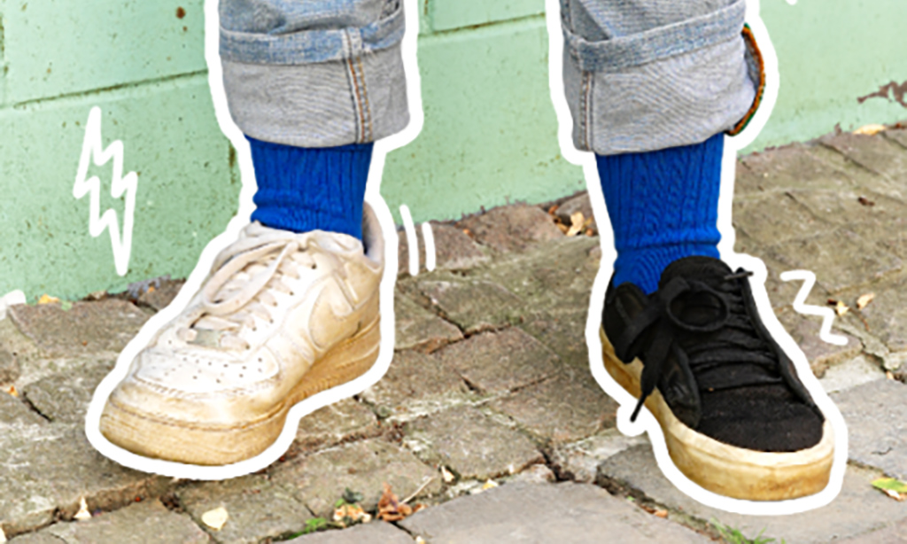 Zwei Füße stecken in zwei unterschiedlich farbigen Schuhen.